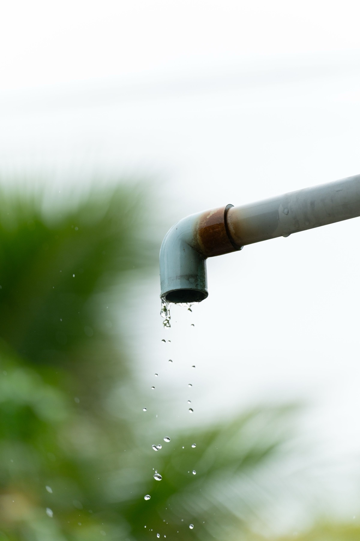 Water dripping from an unbranded outdoor pipe